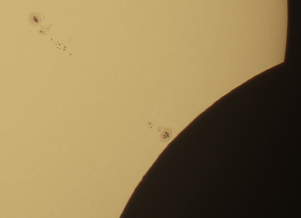 Crop showing sunspots and lunar mountains.